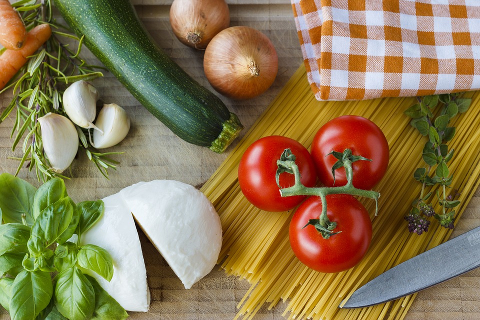 Ingrédients pour une recette italienne : mozzarella, tomates, spaghettis, basilic, courgette, oignons